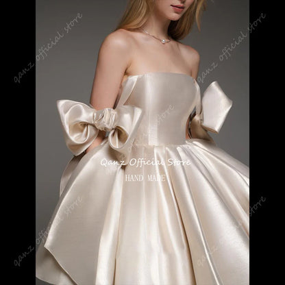 Qanz Robes de Bal Courtes en Champagne à Bretelles Nœud, Robe de Remise de Diplôme sans Bretelles en Satin, Robe d'Anniversaire Personnalisée à Lacets au Dos pour Femmes